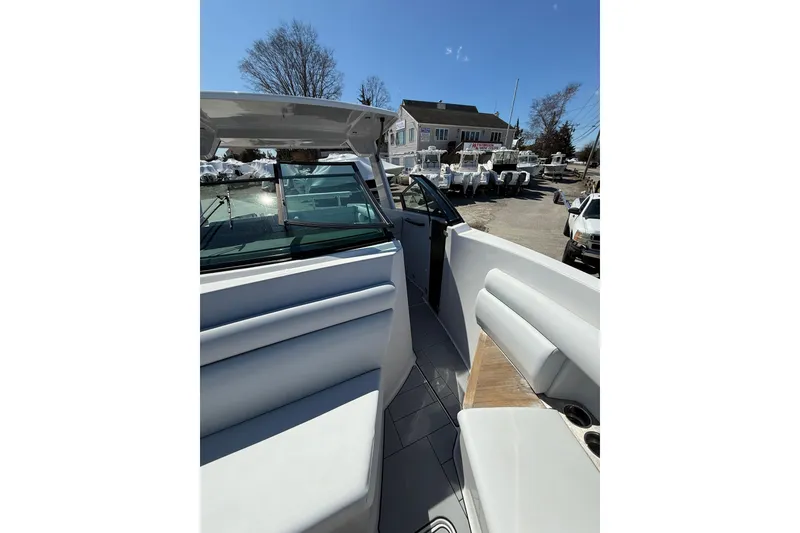 Slide: The Image of 2023 Aviara AV32 I/O boat interior with seating and windshield, parked outdoors. - 13