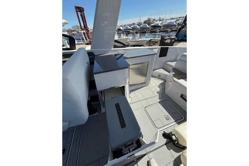 Slide: The Image of 2023 Aviara AV32 I/O boat interior with seating and storage, docked at marina. - 18