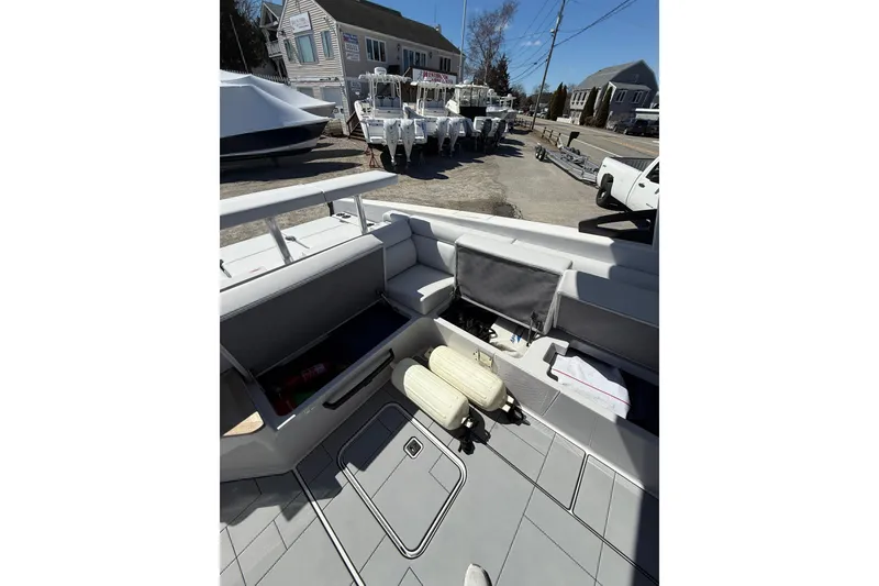 Slide: The Image of 2023 Aviara AV32 I/O boat interior with open storage compartments and docked in a marina. - 21