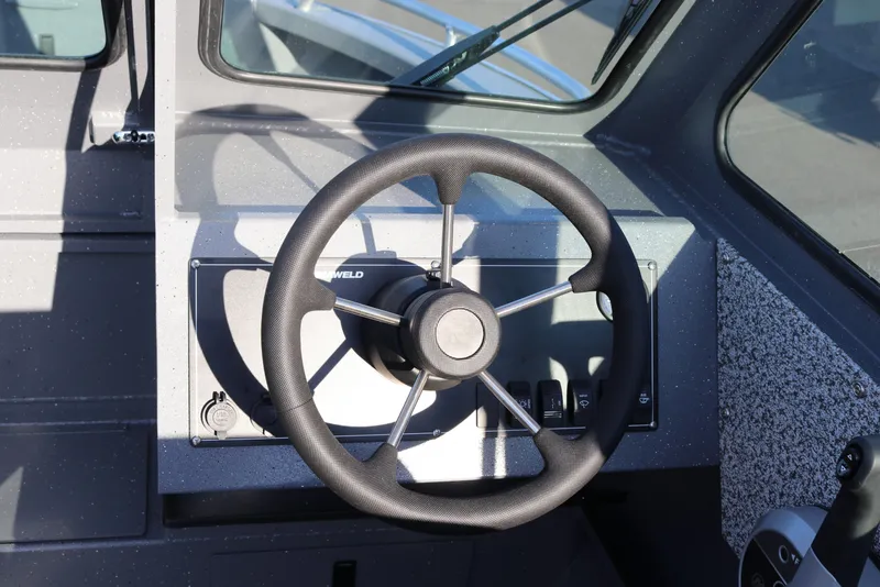 Slide: The Image of 2026 Alumaweld Stryker 220 boat steering wheel and dashboard controls. - 12