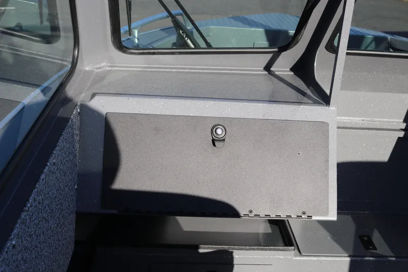 Slide: The Image of 2026 Alumaweld Stryker 220 boat interior with storage compartment and window view. - 13