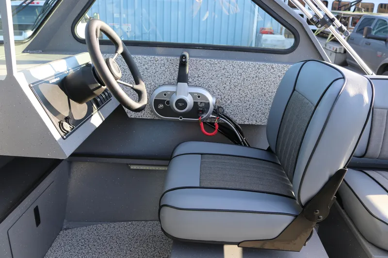 Slide: The Image of 2026 Alumaweld Stryker 220 boat interior with steering wheel and seating. - 16