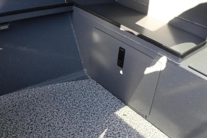 Slide: The Image of Interior of 2026 Alumaweld Stryker 220 boat with speckled flooring and storage compartment. - 20