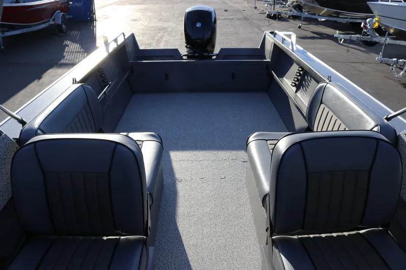 Slide: The Image of 2026 Alumaweld Stryker 220 boat interior with seating and motor, parked on a trailer. - 28