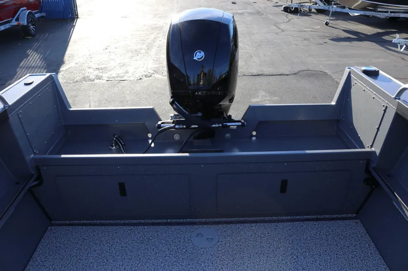 Slide: The Image of 2026 Alumaweld Stryker 220 boat with a powerful outboard motor, docked on pavement. - 34