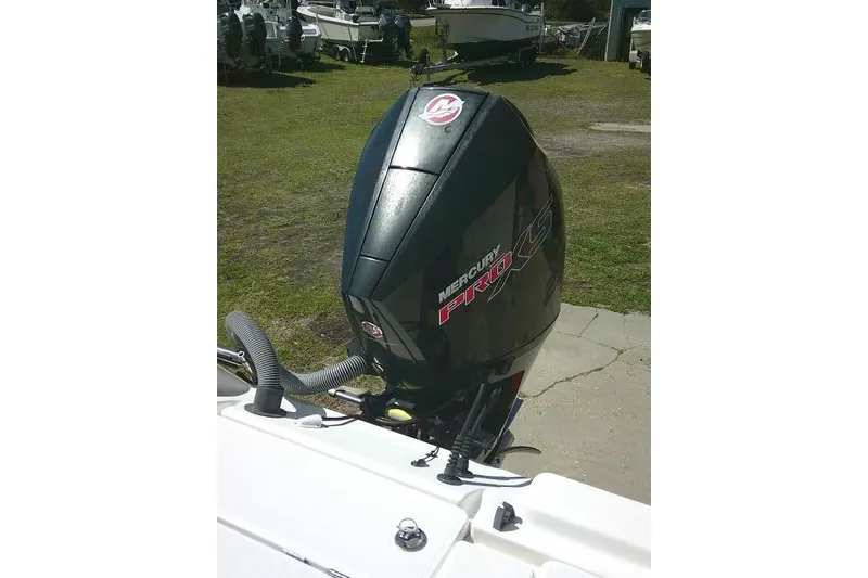 Slide: The Image of Outboard motor on a 2005 Century 2201 Bay Boat, parked on grass. - 27