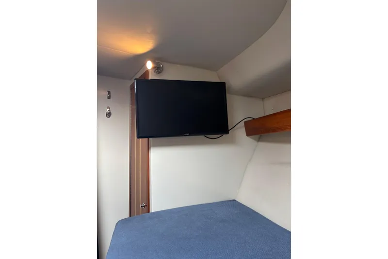 Slide: The Image of Interior cabin of 2005 Ocean Sport Roamer #12 with mounted TV and cozy bed. - 11
