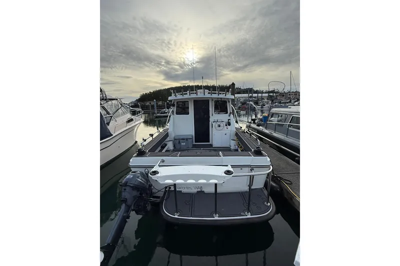 Slide: The Image of 2005 Ocean Sport Roamer #12 docked at marina under cloudy sky. - 12