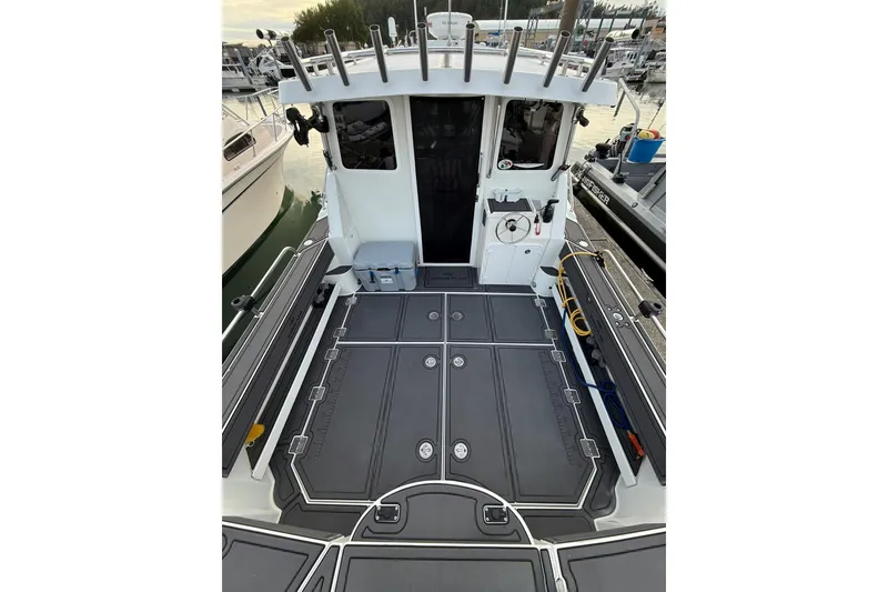 Slide: The Image of 2005 Ocean Sport Roamer #12 boat deck with fishing rod holders and storage compartments. - 14