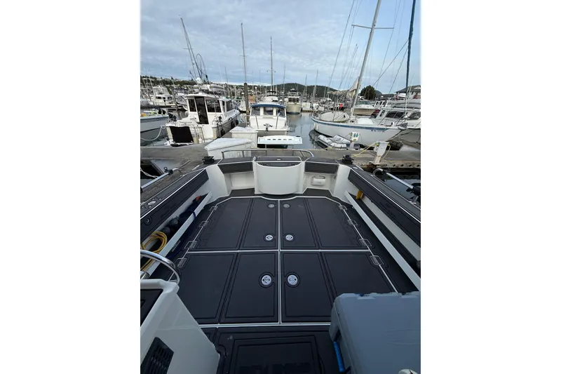 Slide: The Image of 2005 Ocean Sport Roamer #12 boat docked at a marina, showcasing spacious deck. - 15