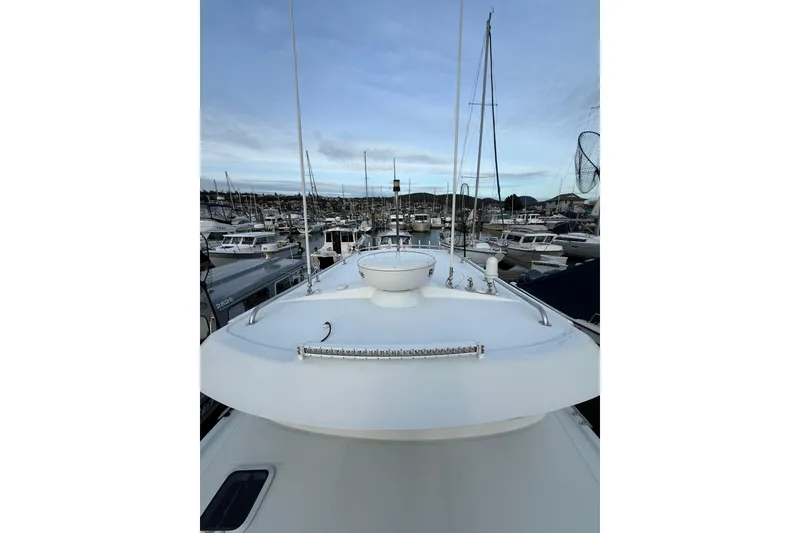 Slide: The Image of 2005 Ocean Sport Roamer #12 boat docked in a marina, surrounded by other vessels. - 18