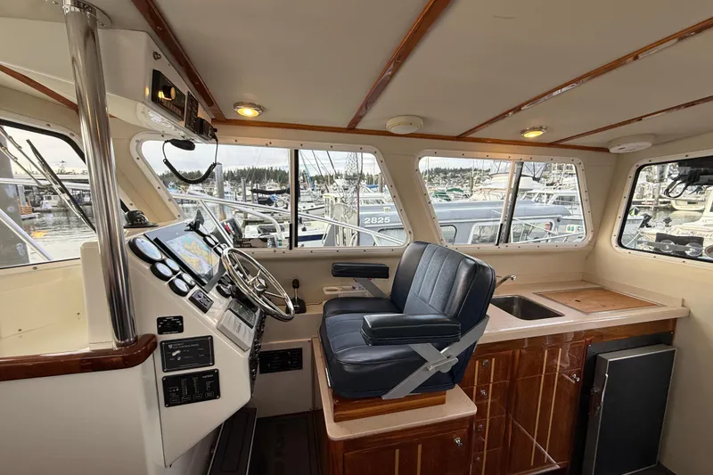 Slide: The Image of Interior of 2005 Ocean Sport Roamer #12 boat with helm, seating, and marina view. - 3