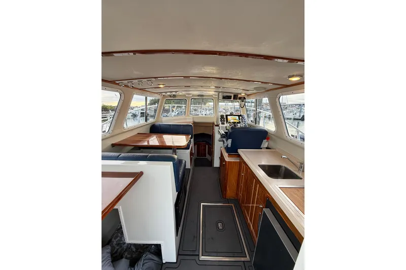 Slide: The Image of Interior of 2005 Ocean Sport Roamer #12 boat with seating, table, and kitchenette. - 6