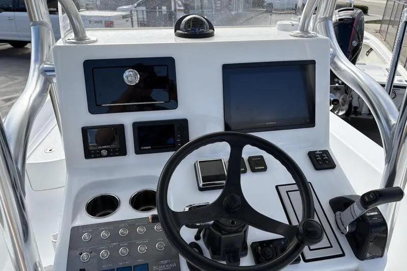 Slide: The Image of Control panel of a 2020 Islamorada 24 Morada boat with steering wheel and navigation screens. - 13