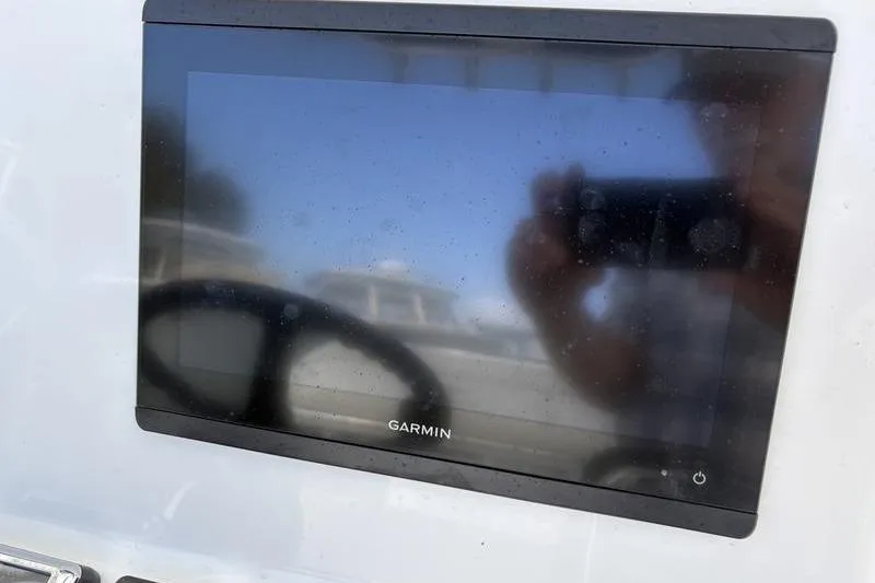 Slide: The Image of Garmin display on 2020 Islamorada 24 Morada boat dashboard, reflecting surroundings. - 16