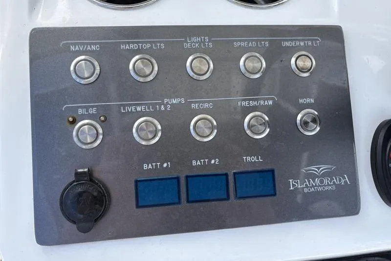 Slide: The Image of Control panel of a 2020 Islamorada 24 Morada boat with various switches and indicators. - 14