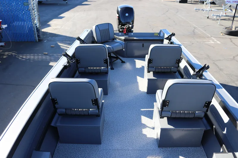 Slide: The Image of 2026 Alumaweld Super Vee 20 boat interior with seating and motor, parked on pavement. - 22