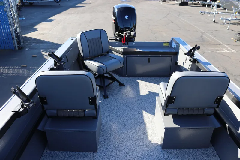 Slide: The Image of 2026 Alumaweld Super Vee 20 boat interior with seating and motor, parked outdoors. - 23