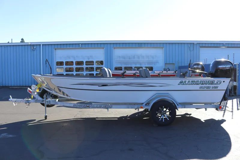 Slide: The Image of 2026 Alumaweld Super Vee 20 boat on trailer, parked outside a blue building. - 4