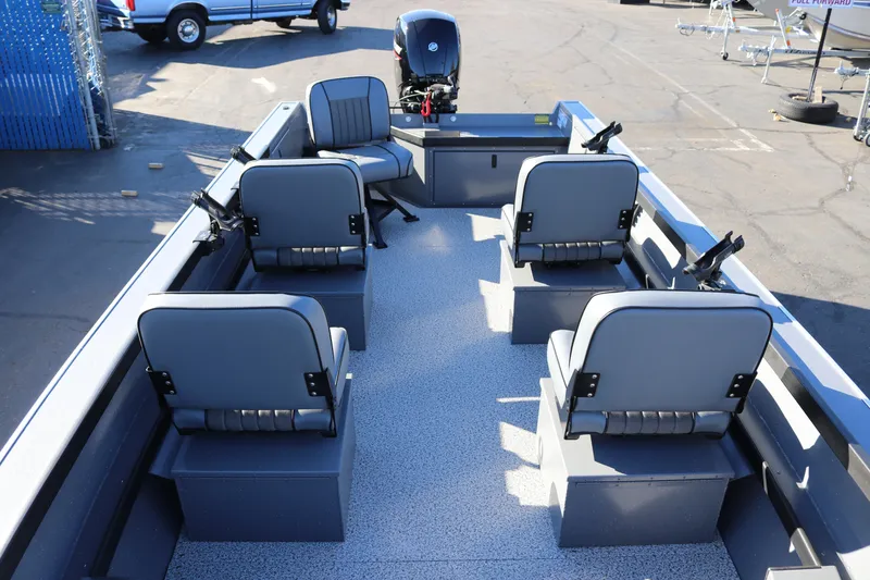 Slide: The Image of 2026 Alumaweld Super Vee 20 boat interior with seating and motor, parked outdoors. - 8
