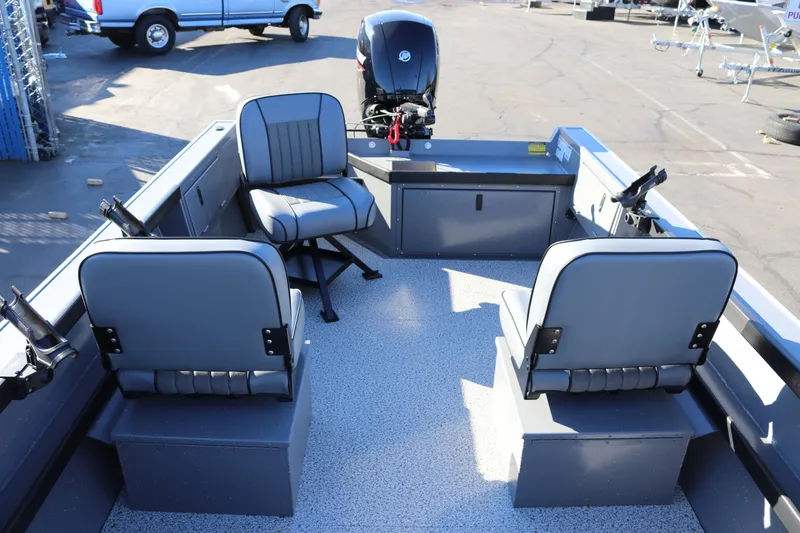 Slide: The Image of 2026 Alumaweld Super Vee 20 boat interior with seating and motor, parked outdoors. - 9