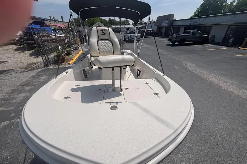 Slide: The Image of 2020 Carolina Skiff 192 JLS boat with seating and canopy in a parking lot. - 10