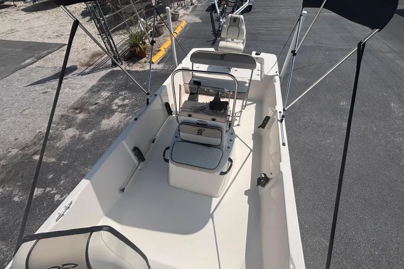 Slide: The Image of 2020 Carolina Skiff 192 JLS boat with seating and canopy, parked on pavement. - 16