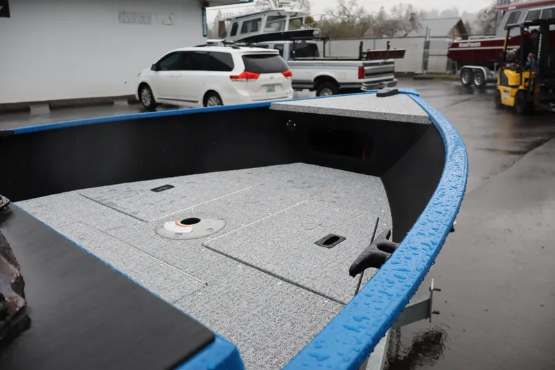 Slide: The Image of 2026 Smoker Craft Lazer 161 boat with wet deck in a parking lot. - 12