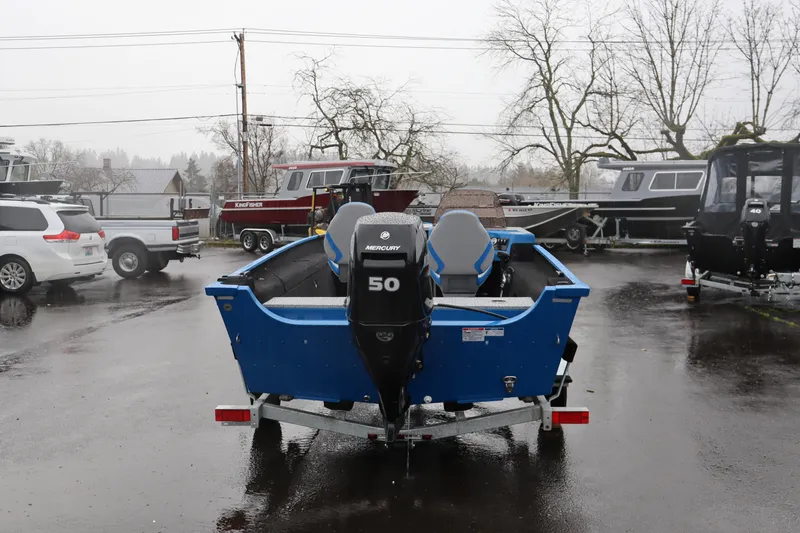 Slide: The Image of 2026 Smoker Craft Lazer 161 boat with Mercury 50 engine in a rainy parking lot. - 5