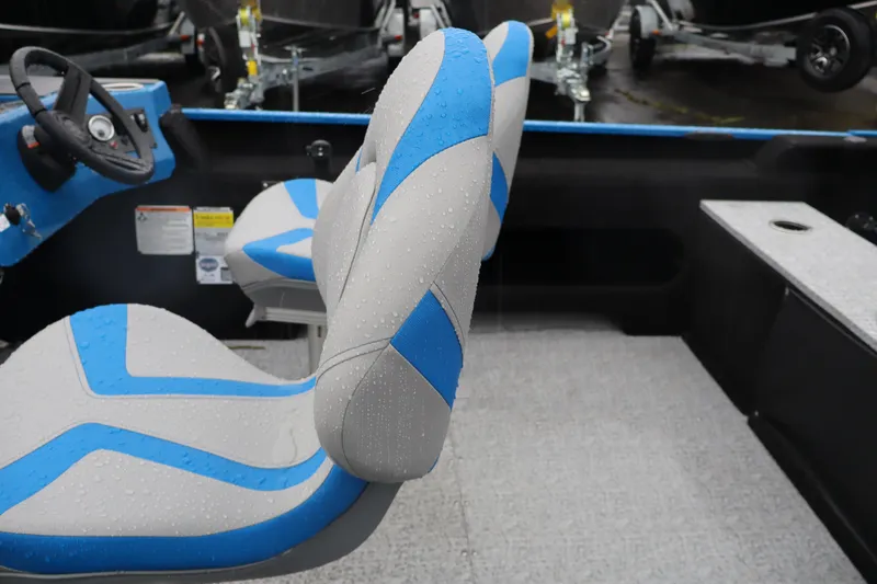 Slide: The Image of 2026 Smoker Craft Lazer 161 boat interior with blue and gray seats, steering wheel visible. - 7