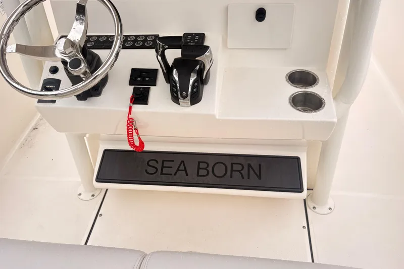 Slide: The Image of 2023 Sea Born LX26 Center Console helm with steering wheel and controls. - 13