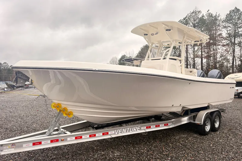 Slide: The Image of 2023 Sea Born LX26 Center Console boat on trailer, parked outdoors. - 2
