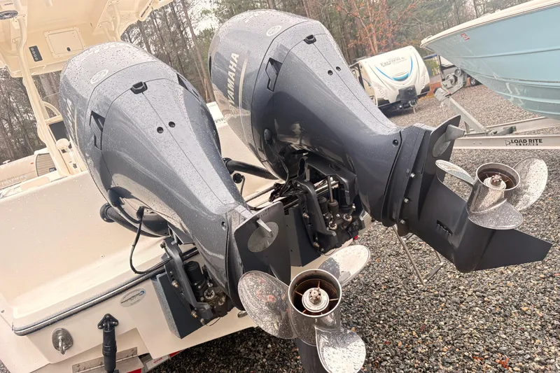 Slide: The Image of 2023 Sea Born LX26 Center Console with dual Yamaha outboard motors in a gravel lot. - 4