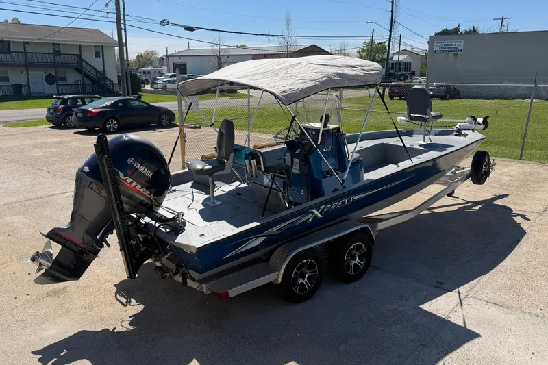 Slide: The Image of 2015 Xpress H22B Bay boat with Yamaha motor on trailer in parking lot. - 4