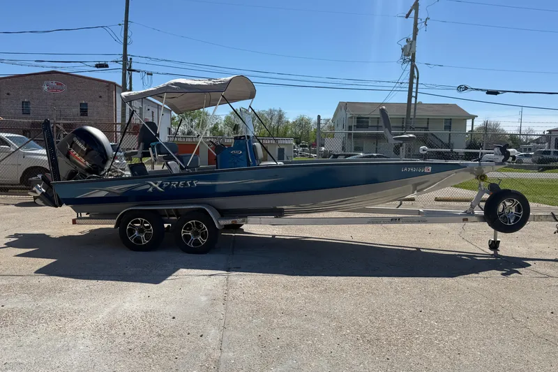 Slide: The Image of 2015 Xpress H22B Bay boat on trailer, parked outdoors under clear sky. - 5