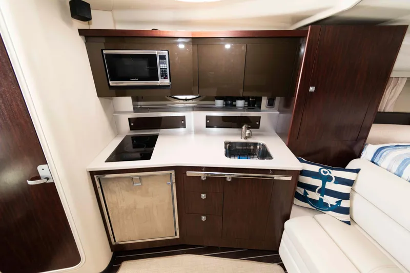 Slide: The Image of Compact kitchen area in a 2015 Monterey 355 Sport Yacht with modern amenities. - 11