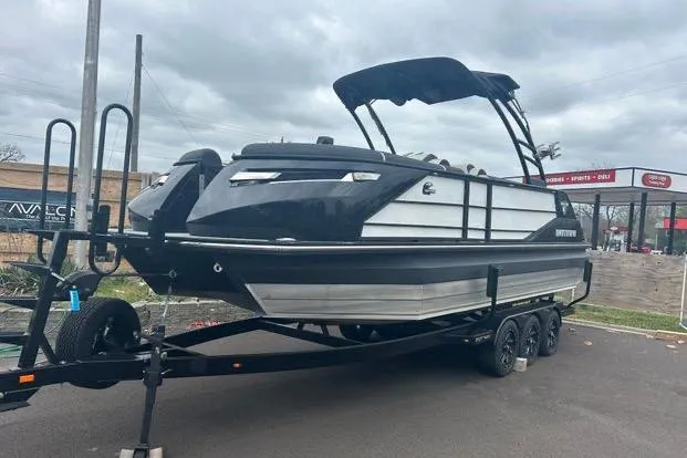 Slide: The Image of 2022 Montara 25 Surf Boss 2.0 CW boat on trailer, black and silver design. - 2