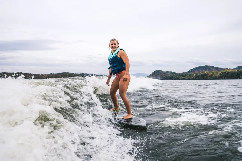 Slide: The Image of Person wakesurfing behind 2022 Montara 25 Surf Boss 2.0 CW boat on a lake. - 6