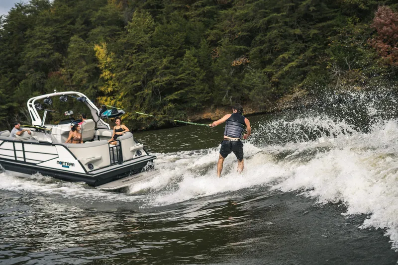 Slide: The Image of 2022 Montara 25 Surf Boss 2.0 CW towing a wakeboarder on a scenic lake. - 8