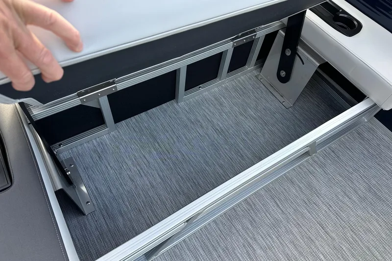 Slide: The Image of 2026 Bennington 22 SSB SwingBack storage compartment with gray flooring and aluminum frame. - 20