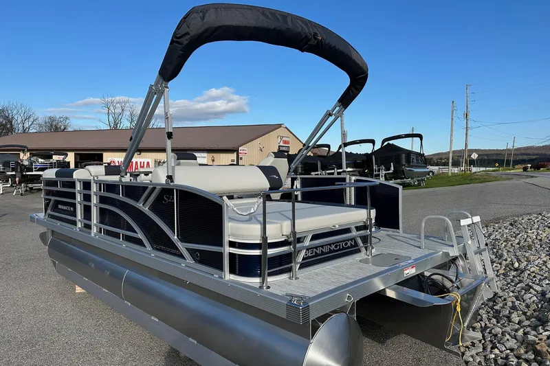 Slide: The Image of 2026 Bennington 22 SSB SwingBack pontoon boat with Yamaha 90 Hp engine, parked outdoors. - 29