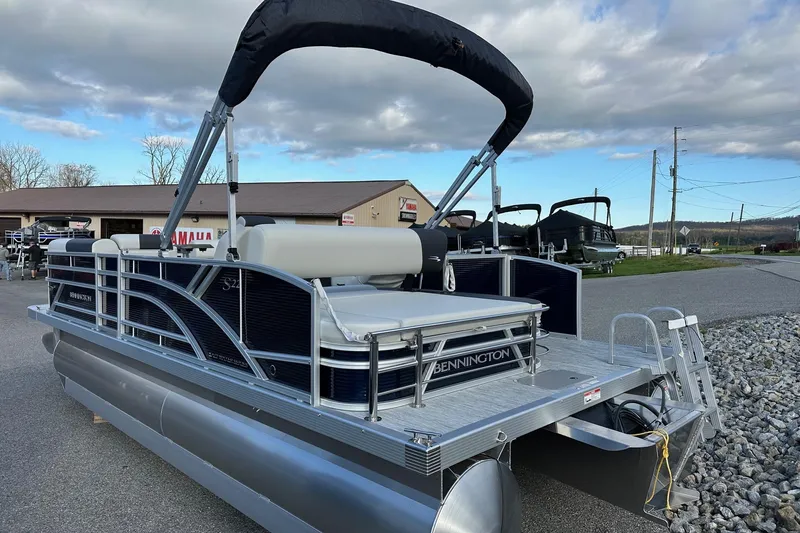 Slide: The Image of 2026 Bennington 22 SSB SwingBack pontoon boat with Yamaha 90 Hp engine, parked outdoors. - 5