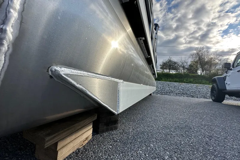 Slide: The Image of 2026 Bennington 22 SSB pontoon boat on trailer, side view with cloudy sky. - 7