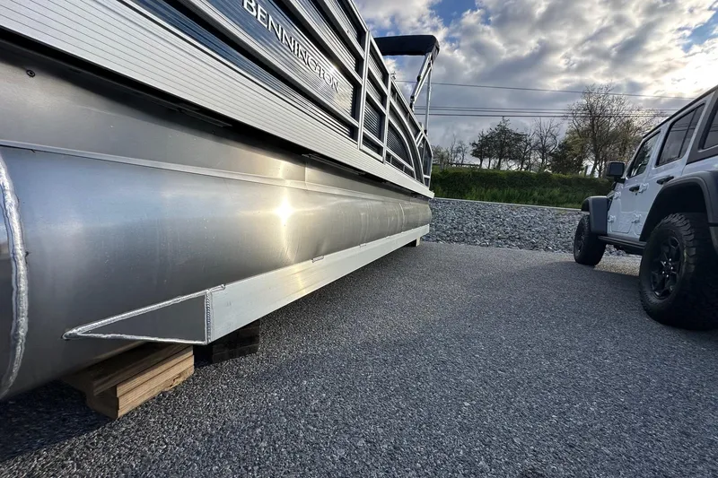 Slide: The Image of 2026 Bennington 22 SSB pontoon boat with Yamaha 90 HP engine, parked beside a vehicle. - 8