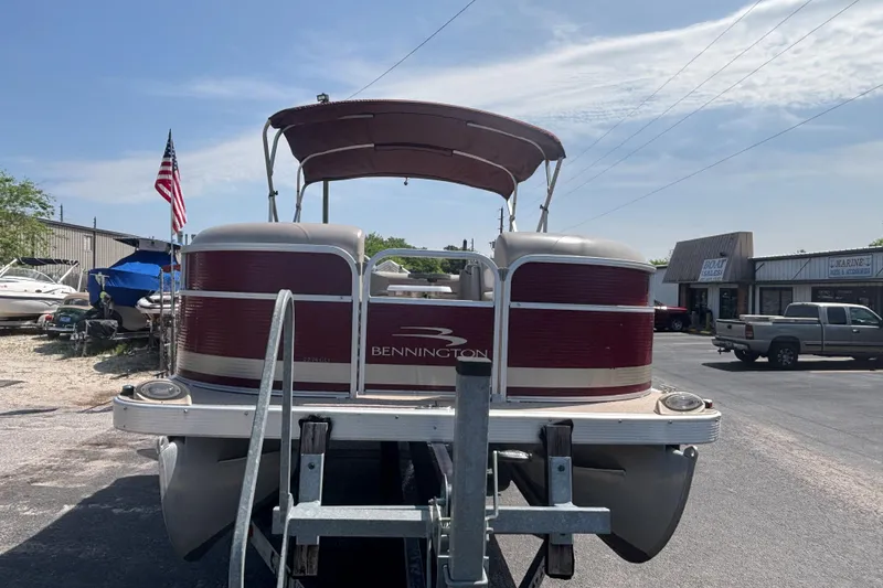 Slide: The Image of 2010 Bennington 2274GLi pontoon boat on trailer, parked near dealership. - 6