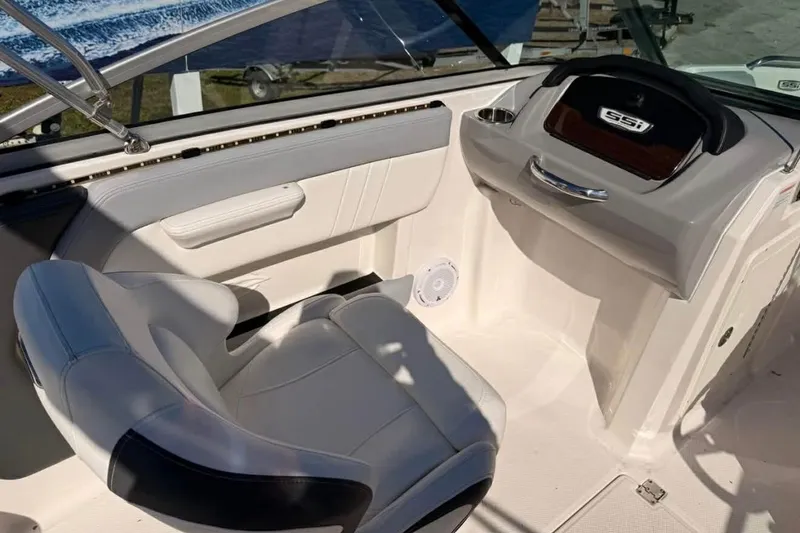 Slide: The Image of 2022 Chaparral 21 SSi OB boat interior with white seating and dashboard. - 15