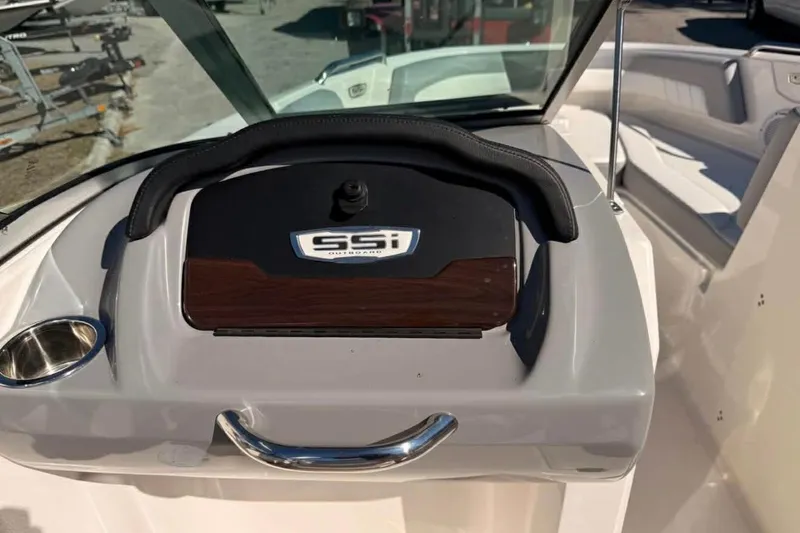 Slide: The Image of 2022 Chaparral 21 SSi OB boat dashboard with steering wheel and cup holder. - 8