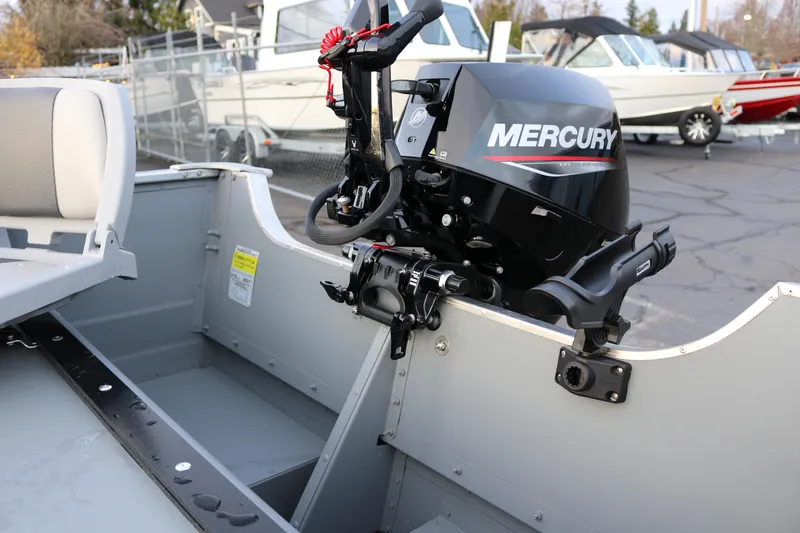 Slide: The Image of 2026 Smoker Craft Alaskan 15 boat with Mercury outboard motor, parked outdoors. - 11