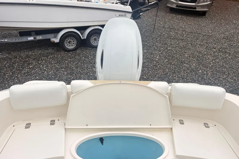 Slide: The Image of 2022 Bulls Bay 230 Center Console boat with seating and livewell, parked on gravel. - 4