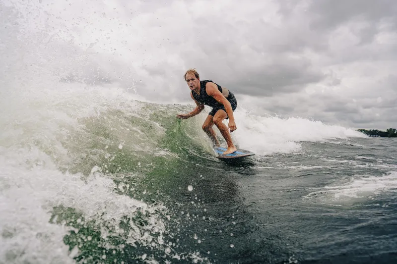 Slide: The Image of Surfer riding wave behind 2024 Montara 23 Surf Boss 2.0 CW boat. - 4